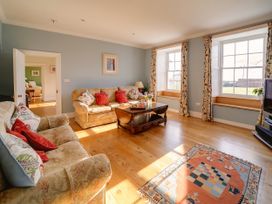 A living room with a sofa and a coffee table at Porthcothan House in St Merryn