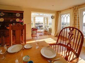 A dining room with a table set for meals at Porthcothan House in St Merryn