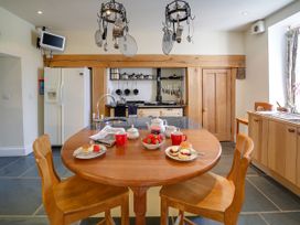 A kitchen with a round table and chairs at Porthcothan House St Merryn
