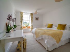 A bedroom with a bed and window at Porthcothan House in St Merryn