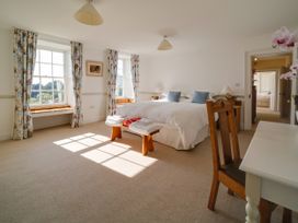 A bedroom with a bed and windows at Porthcothan House St Merryn