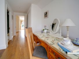 A hallway with a desk and chair at Porthcothan House in Porthcothan