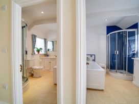 A bathroom with a shower and bathtub at Porthcothan House in Porthcothan