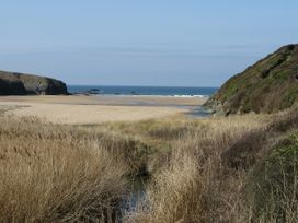 A beach view with sand and sea at Porthcothan House in Porthcothan
