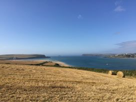A view of a beach and sea with hills in the background at Porthcothan House, Porthcothan
