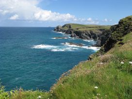 An ocean view with rocks and grass at Porthcothan House in Porthcothan