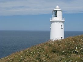 A lighthouse overlooking the sea at Porthcothan House in Porthcothan