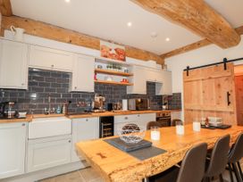 A kitchen with wooden beams and a wooden table with candles and a wire bowl at Pine Marten Lodge Dulnain Bridge near Nethy Bridge