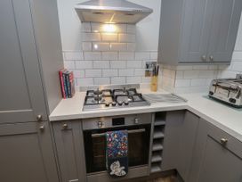 A kitchen with a gas stove oven range cooker knives on a block cookbooks and a toaster at Rookley Lake Cottage Rookley near Godshill