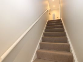 A carpeted staircase with a white handrail and walls at Rookley Lake Cottage in Rookley near Godshill