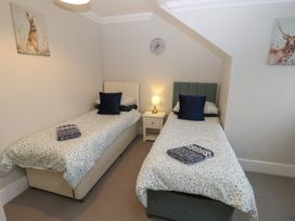 A bedroom with two single beds separated by a nightstand with a lamp at Rookley Lake Cottage Rookley near Godshill
