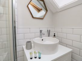 A bathroom sink with a faucet a mirror and toiletry items at Rookley Lake Cottage in Rookley near Godshill