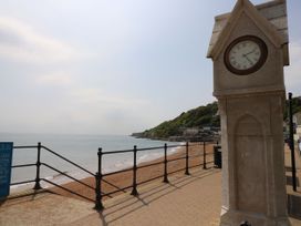 A seaside promenade with a clock tower overlooking a beach and the ocean at Rookley Lake Cottage in Rookley near Godshill
