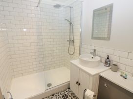 A bathroom with a walk-in shower a white sink with a cabinet and a mirror above at Rookley Lake Cottage in Rookley near Godshill