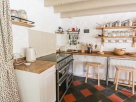 A kitchen with a stove and wooden counter at Sycamore Vestry in Pontfaen near Fishguard