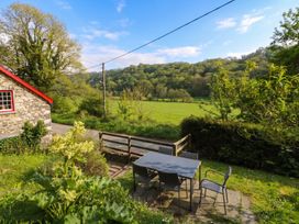 An outdoor seating area with a table and chairs at Sycamore Vestry Pontfaen near Fishguard
