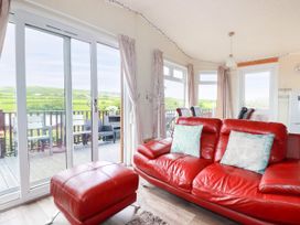 A living room with a red sofa and sliding doors at Chi Prenn Byhan in Tintagel