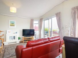 A living room with a television and sofa at Chi Prenn Byhan in Tintagel