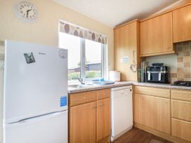 A kitchen with a fridge, sink, and dishwasher at Chi Prenn Byhan in Tintagel
