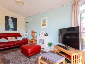 A living room with a red couch and television at Chi Prenn Byhan in Tintagel