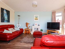 A living room with red furniture and a television at Chi Prenn Byhan in Tintagel