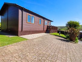 A wooden building with windows and steps at Chi Prenn Byhan in Tintagel