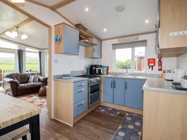 A kitchen with cabinets and appliances at Orchard View in Bossiney near Tintagel