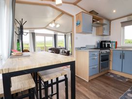A kitchen with a table and chairs at Orchard View in Bossiney near Tintagel