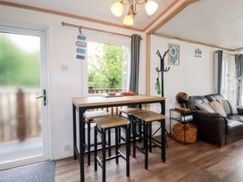 A dining area with a bar table and stools at Orchard View in Bossiney near Tintagel