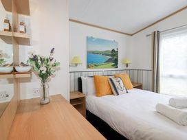A bedroom with a bed and a picture at Orchard View Bossiney near Tintagel