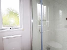 A bathroom with a shower enclosure and toilet at Orchard View in Bossiney near Tintagel
