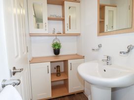 A bathroom with a sink and cabinet at Orchard View in Bossiney near Tintagel