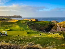 A golf course with ocean view and cliffs at The Captain's Nest in Bunbeg, County Donegal