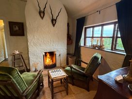 A living room with a fireplace and seating area at The Captain's Nest in Bunbeg, County Donegal