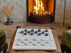 A checkerboard with pieces in front of a fireplace at The Captain's Nest in Bunbeg, County Donegal