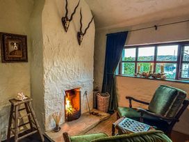 A living room with a fireplace and armchair at The Captain's Nest in Bunbeg, County Donegal