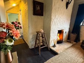 A living room with a fireplace and flowers at The Captain's Nest in Bunbeg, County Donegal