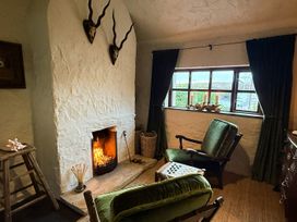 A sitting room with a fireplace and two chairs at The Captain's Nest in Bunbeg, County Donegal