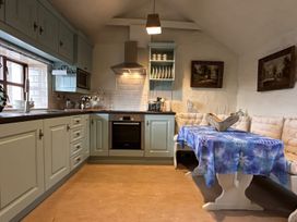 A kitchen with a table and bench in The Captain's Nest, Bunbeg, County Donegal