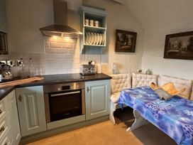 A kitchen with an oven, kettle, and dining table at The Captain's Nest in Bunbeg, County Donegal
