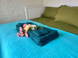 A bed with towels and flowers arranged on top at The Captain's Nest in Bunbeg, County Donegal