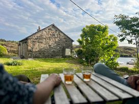 A house with two glasses on a table and greenery at The Captain's Nest in Bunbeg, County Donegal