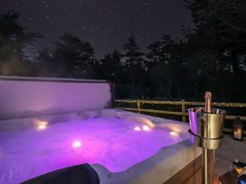 A hot tub with purple lights and a champagne bucket at Stag Cottage in Lytchett Matravers