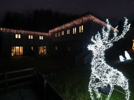 An outdoor scene with a house decorated with lights and a reindeer decoration at Stag Cottage in Lytchett Matravers