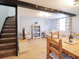 A living room with a sofa and dining area at Burgedin Locks Cottage Arddleen near Llandrinio