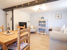 A living room with a dining table and chairs at Burgedin Locks Cottage in Arddleen near Llandrinio