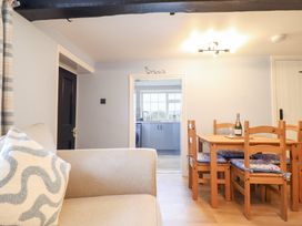 A dining room with a table and chairs at Burgedin Locks Cottage Arddleen near Llandrinio