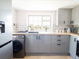 A kitchen with appliances and a window at Burgedin Locks Cottage Arddleen near Llandrinio