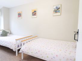 A bedroom with twin beds and artwork on the walls at Burgedin Locks Cottage Arddleen near Llandrinio