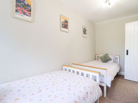 A bedroom with two beds and wall decor at Burgedin Locks Cottage Arddleen near Llandrinio